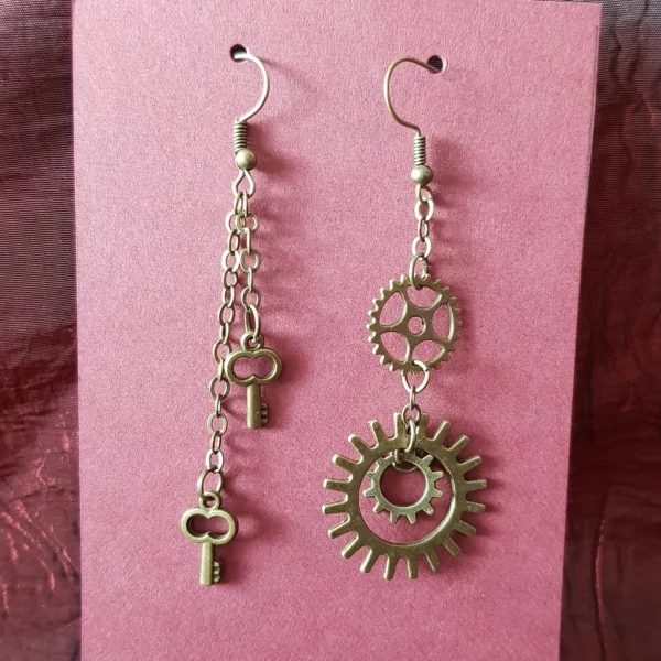 Ces boucles d'oreilles clé et engrenage steampunk, de couleur bronze, apporteront la touche asymétrique parfaite pour booster votre look.