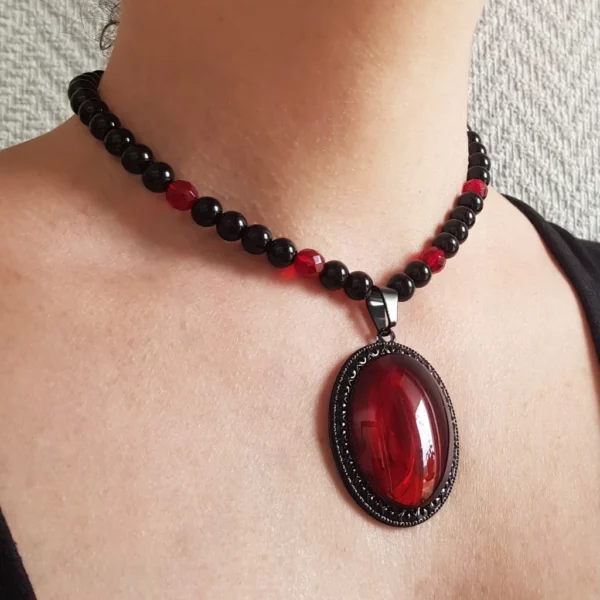 Cet original collier de perles gothique rouge et noir annonce la couleur avec un joli jeu de transparence. De quoi ravire les fans de style gothique!