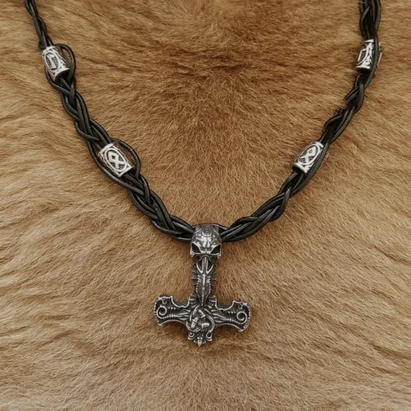 Ce collier en cuir tressé runes viking et Mjöllnir sera du plus bel effet pour finir votre tenue de guerrier avec style. En cuir de vache et acier inoxydable.